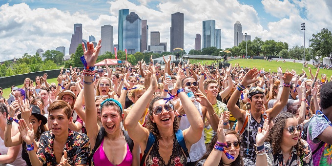 Image of a group of festival goers with a city skyline in the background.