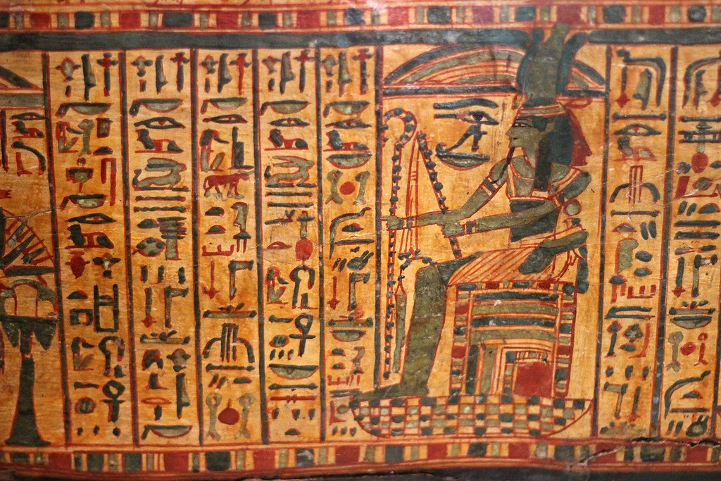 An image of Egyptian hieroglyphs alongside a depiction of an Egyptian diety.